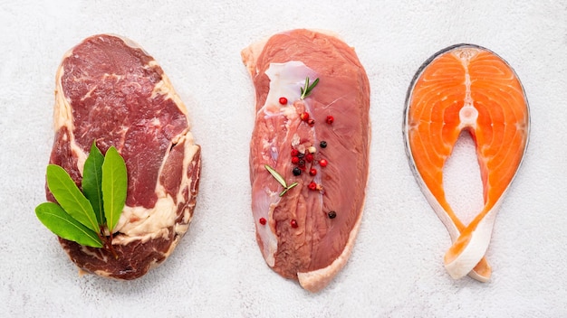 Steak concept with salmon steak rib eye steak and duck breast set up on white concrete background