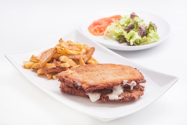 Steak filled cheese and ham san jacobo librito with salad and potatoes chips