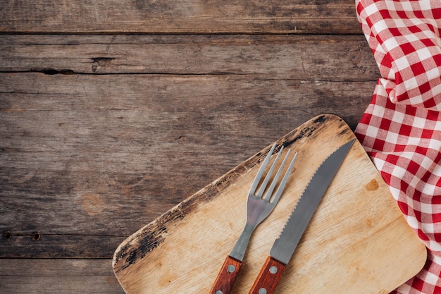 Steak fork and knife on wooden background