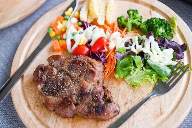 Steak homemade with french fries and fresh vegetable salad on wooden tray healthy steak menu Steak pork