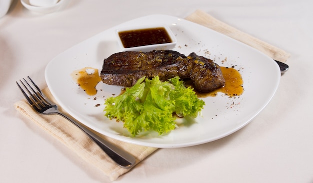 Steak on Plate with Garnish at Place Setting in Restaurant