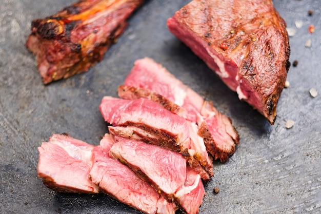 Steakhouse menu. Cowboy steak. Top view closeup of sliced grilled beef meat and bone.