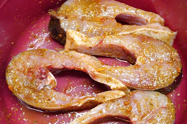 steaks in a marinade dish with herbs closeup on a kitchen