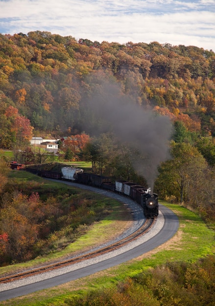 Steam train powers along railway