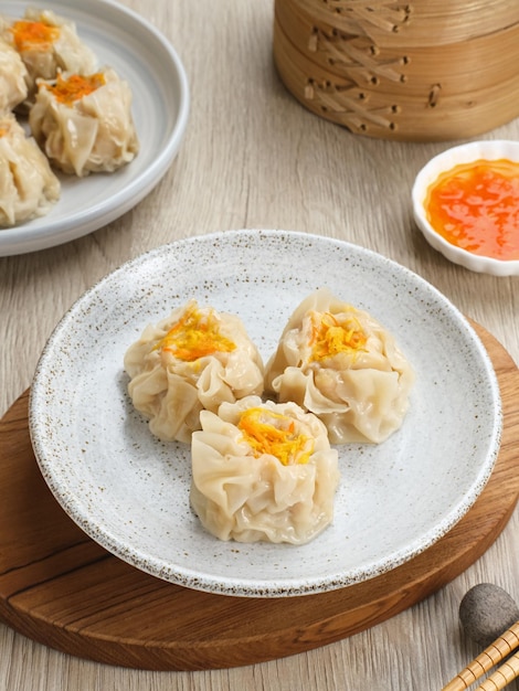 Steamed dumpling dimsum served in plate with chilli sauce