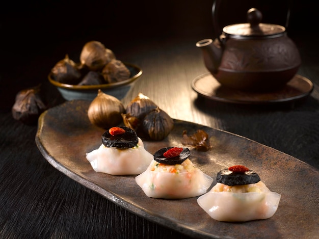 Steamed Dumpling with Minced Meat and Black Garlic served in dish isolated on table top view of food