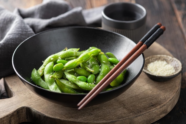 Steamed edamame beans in a black ceramic bowl soybeans selective focus