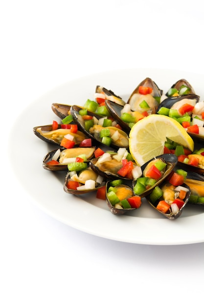 Steamed mussels with peppers and onion isolated on white  close up