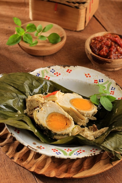 Steamed Salted Egg (Pepes Telur Asin) Wrapped with Banana Leaf and Garnish with Lemon Basil