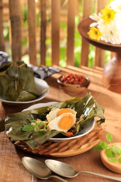 Steamed Salted Egg (Pepes Telur Asin) Wrapped with Banana Leaf and Garnish with Lemon Basil