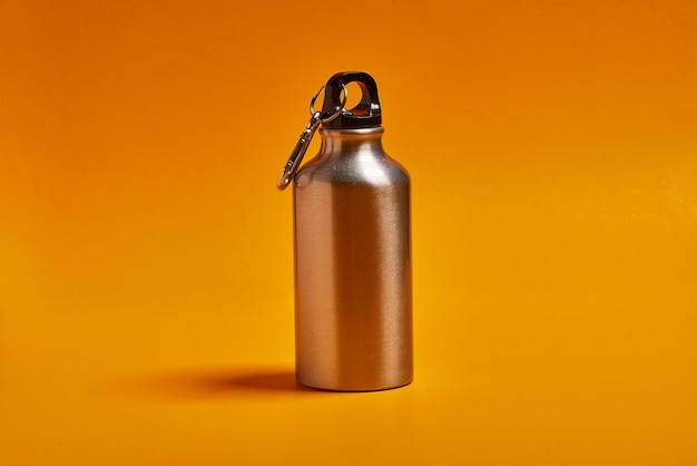 steel canteen for adventure with water on yellow background