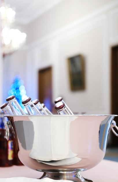 A steel cooler with chilled bottles stands on a buffet table