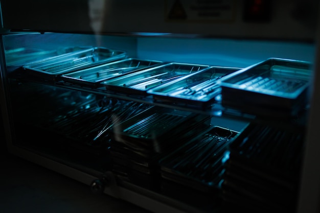 Steel dental instruments lying in a sterilizer under ultraviolet