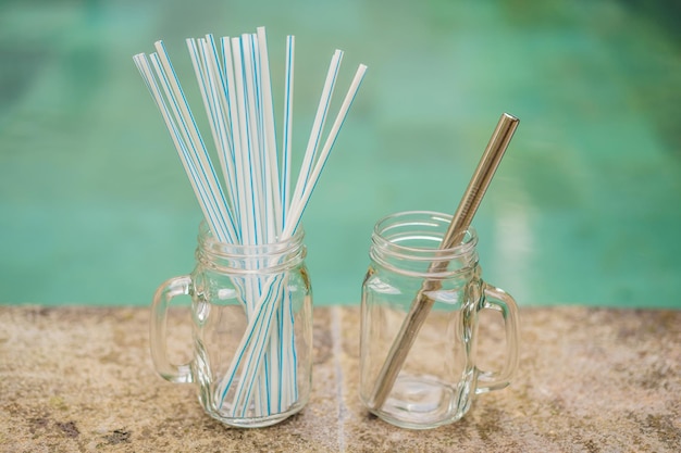 Steel drinking vs disposable straws on pool background zero waste concept