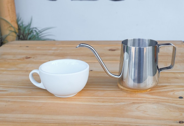 Steel long spout drop kettle on wood table