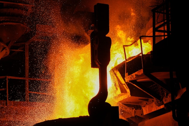 Steel production in electric furnaces. Sparks of molten steel. Electric arc furnace shop EAF. Metallurgical production, heavy industry, engineering, steelmaking.