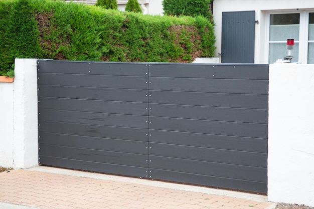 Steel sliding high grey metal gate on modern house street