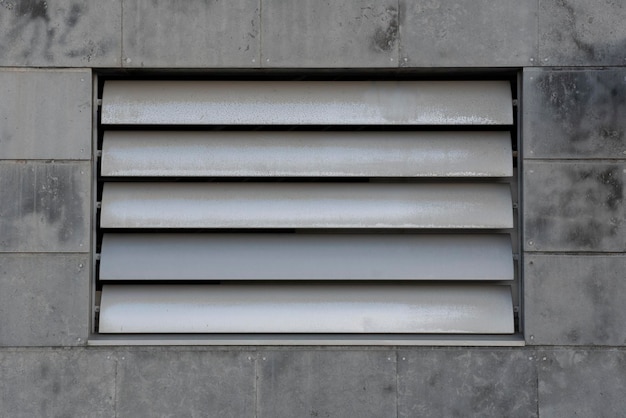 Steel ventilation shutters on a concrete tile facade metal louvers