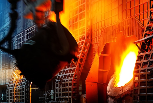 Steelworker at work pouring metal in the workshop