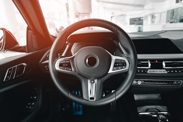 Steering wheel of a new luxury car close up