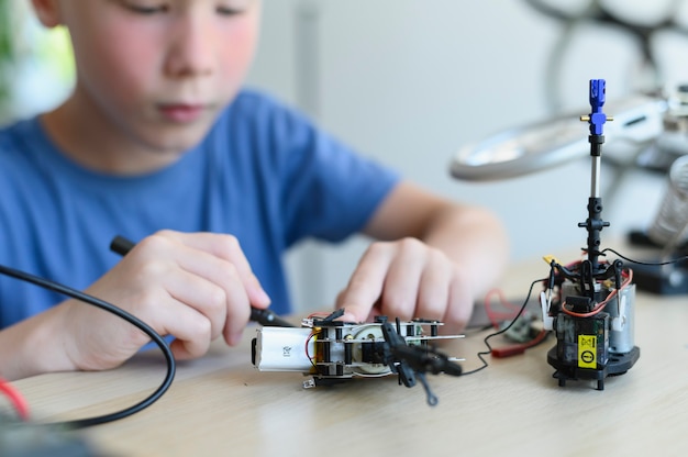 Stem education clever kid assemble and learn to program his robot for school project smart boy