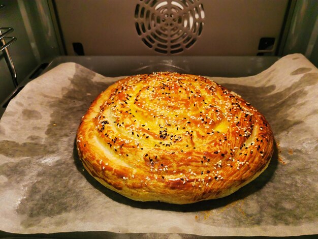 Step 3 Burek with spinach and ricotta cheese Round pie with cheese herbs greased