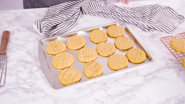 Step by step. Freshly baked peanut butter cookies on baking sheet.