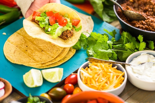 Step by step. Ground beef tacos with romaine lettuce, diced tomatoes, radished, and shredded cheddar cheese.