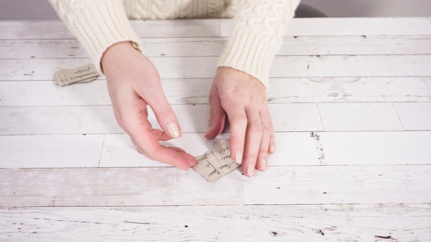 Step by step. Labeling brown paper gift tags with a black marker.