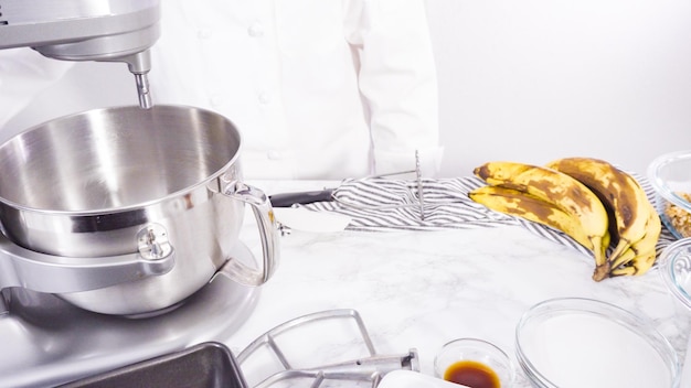 Step by step. Mixing ingredients together into a metal mixing bowl to bake banana bread.