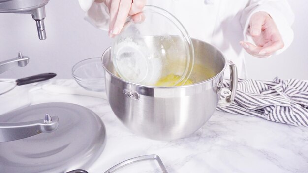 Step by step. Mixing ingredients together into a metal mixing bowl to bake banana bread.