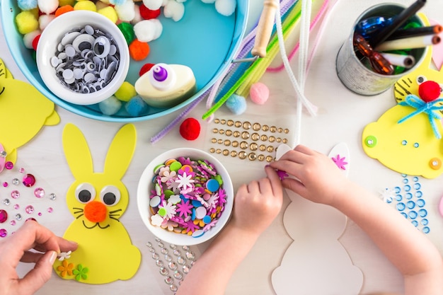 Step by step. Mother and daughter decorating Easter Bunnies.