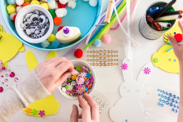 Step by step. Mother and daughter decorating Easter Bunnies.