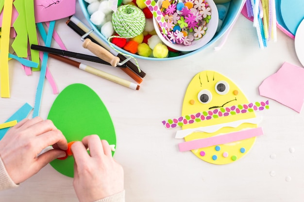 Step by step. Mother and daughter decorating paper Easter eggs.