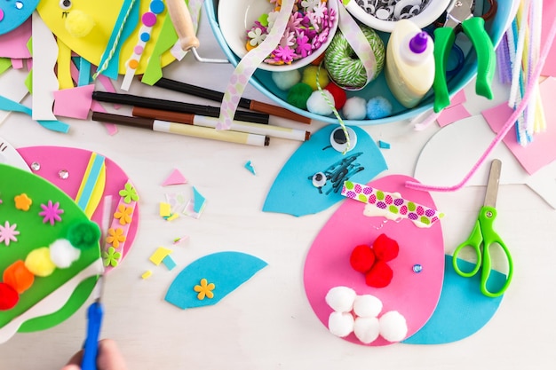 Step by step. Mother and daughter decorating paper Easter eggs.