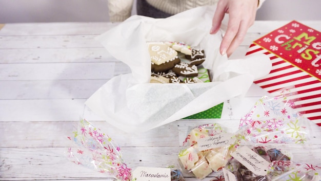 Photo step by step. packaging homemade fudge and cookies into a christmas gift box.