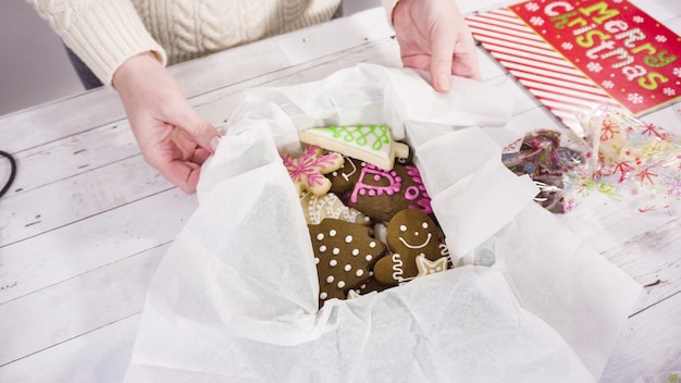 Step by step. Packaging homemade fudge and cookies into a Christmas gift box.