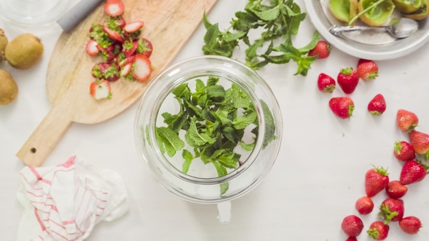 Step by step. Preparing organic infused water in glass beverage drink dispenser.