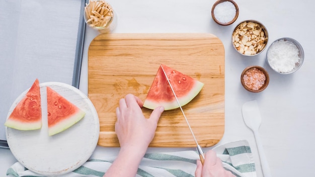 Step by step. Slicing watermelon into cubes for preparing chocolate covered watermelon bites.