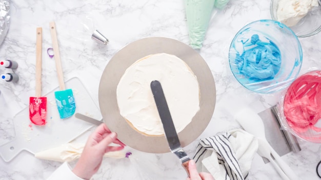 Step by step. Stacking cake layers to create the round three-layer vanilla cake.