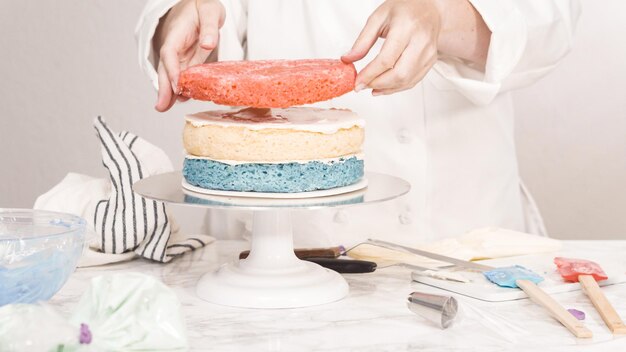 Step by step. Stacking cake layers to create the round three-layer vanilla cake.