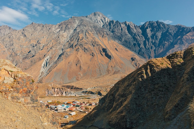 Stepantsminda, Kazbegi, Goergia. Cityscape of big rural town with mountain range of Kazbak.