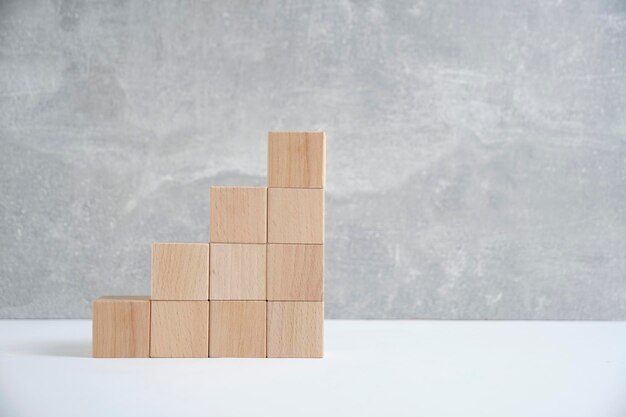 Steps made of wooden cubes light concrete backgroundEmpty space for text