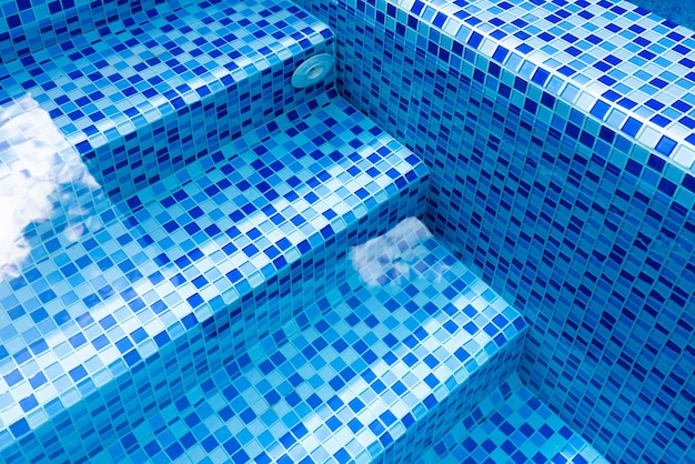 Steps in the pool with blue ceramic tile mosaic Relax in the backyard of a country house