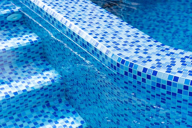 Steps in the pool with blue ceramic tile mosaic Relax in the backyard of a country house