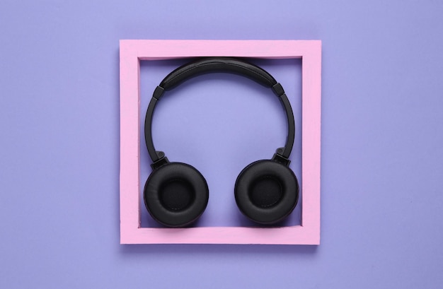 Stereo headphones in a frame on a purple background