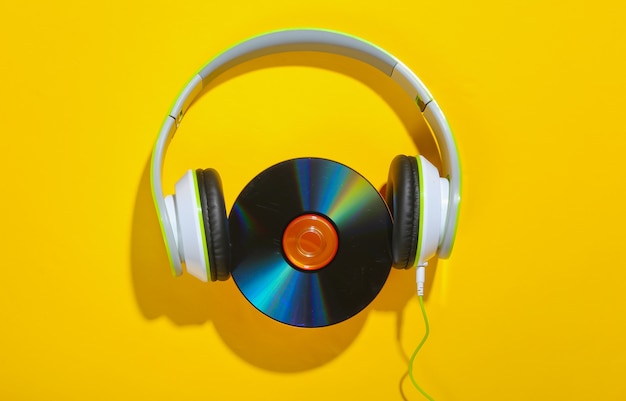 Stereo headphones with cd disk on a yellow surface