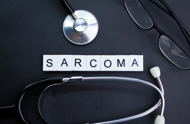 stethoscope and alphabet letters with the word sarcoma concept of medicine and disease