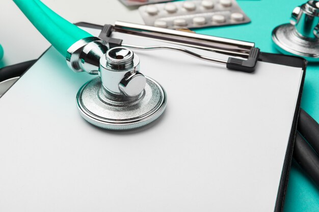 Stethoscope, clipboard and pills, closeup. Medical equipment