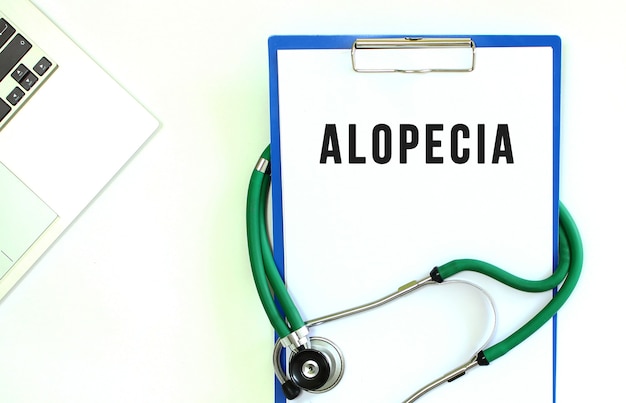 Stethoscope and clipboard with ALOPECIA text on white sheet of paper and copy space.